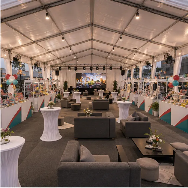 Inside view of modular marquee with customer lounge seating, vendor tables, booth fair counters, fans and cocktail tables