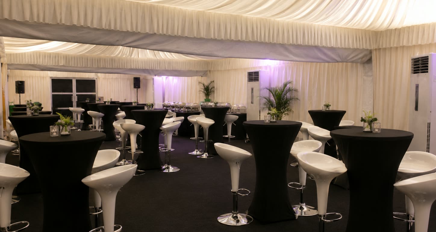 Black and white cocktail marquee lounge with high tables, white bar stools and pearl ceiling drapes