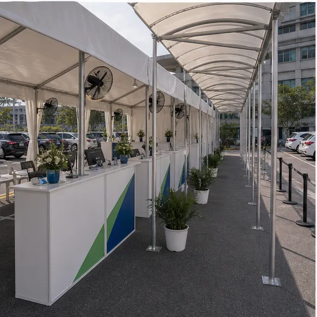 Side view of a queue canopy with temporary support counters, covered walkway, queue barriers and accessible route