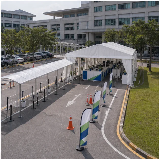 High angle view of a hospital outdoor support layout with waiting marquee, queue canopy, support counters and driveway access