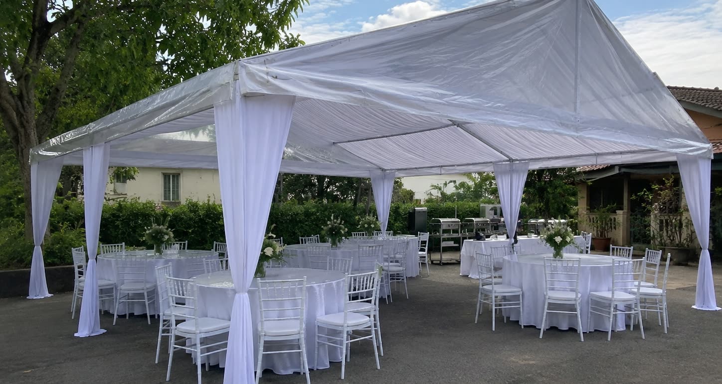 Pearl white canopy exterior with round dining tables, white chairs and garden shrubs