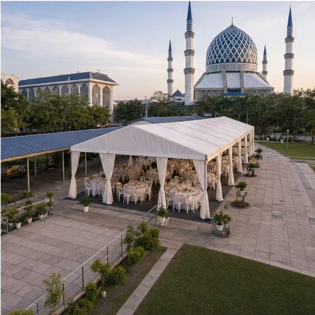 High angle view of mosque compound guest seating layout with white marquee, dining tables, buffet area and paved plaza access
