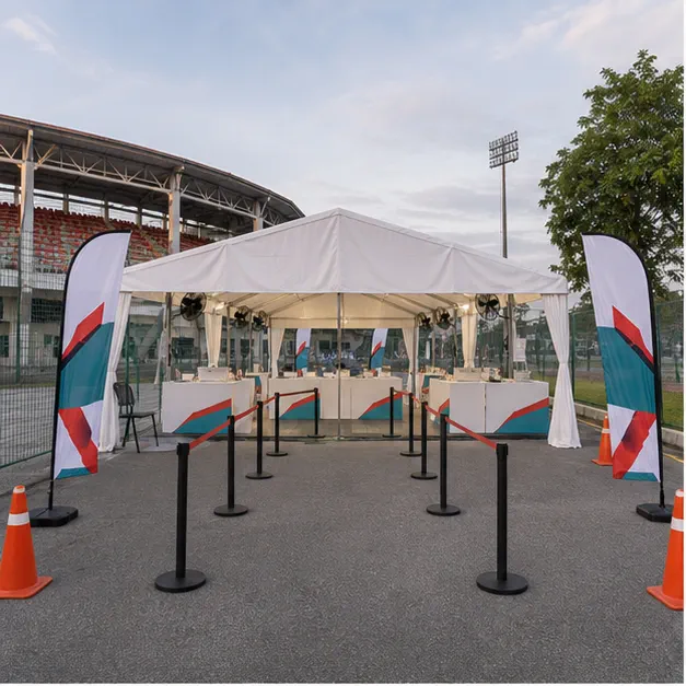 Stadium MBPJ Kelana Jaya tournament setup with white marquee, registration canopy, spectator seating, counters and queue lane