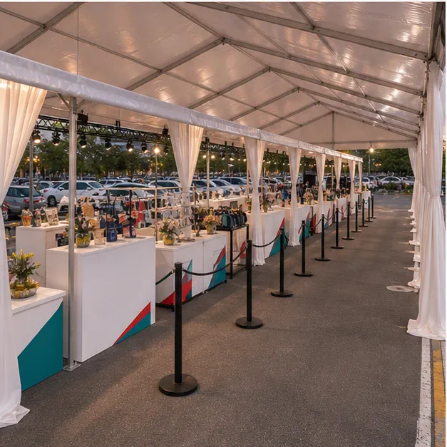 Side view of mall sale event setup with booth tables, display racks, queue barriers, counters and covered guest route