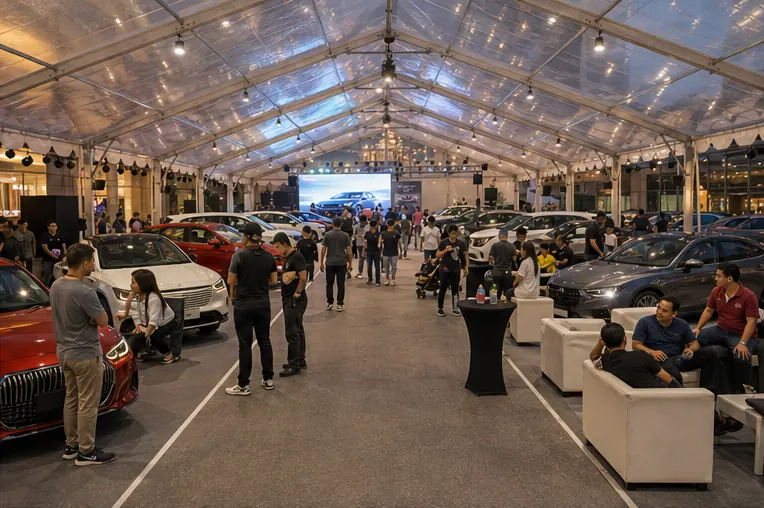 Inside view of a clear span marquee automotive display with cars, LED screen, cocktail tables, guest seating and product lighting