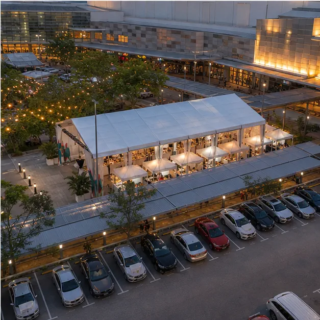 High angle view of a weekend bazaar layout with modular marquee, vendor rows, mall concourse, car park edge and guest movement