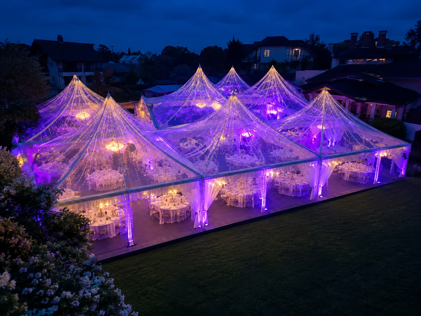 Evening transparent Arabian canopy banquet setup with clear roofs, purple lighting, warm chandeliers, white drapes and round dining tables