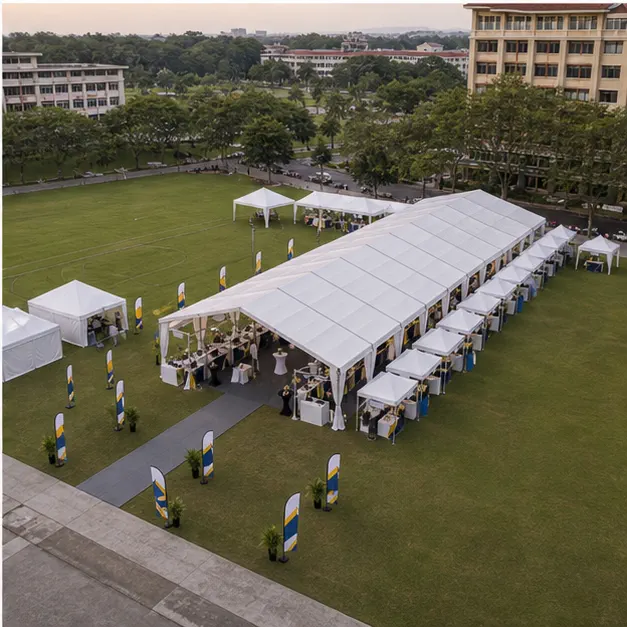 High angle view of a campus field event layout with classic marquee, booth rows, lounge tables, field access and walking lanes