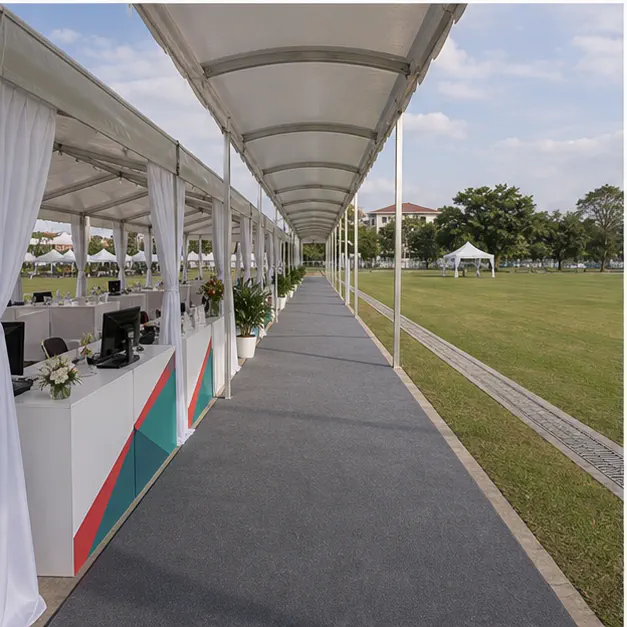 Side view of a covered walkway canopy connecting an open field marquee, registration counters and sports village booths