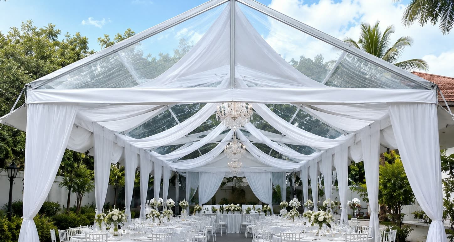 Daytime clear roof wedding marquee with pearl drapes, chandeliers, white tables and white chairs